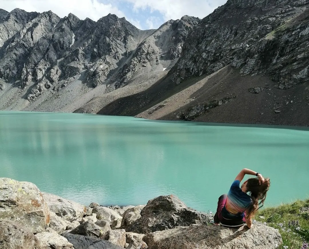 Woman against the backdrop of the high mountain lake Ala-Kol