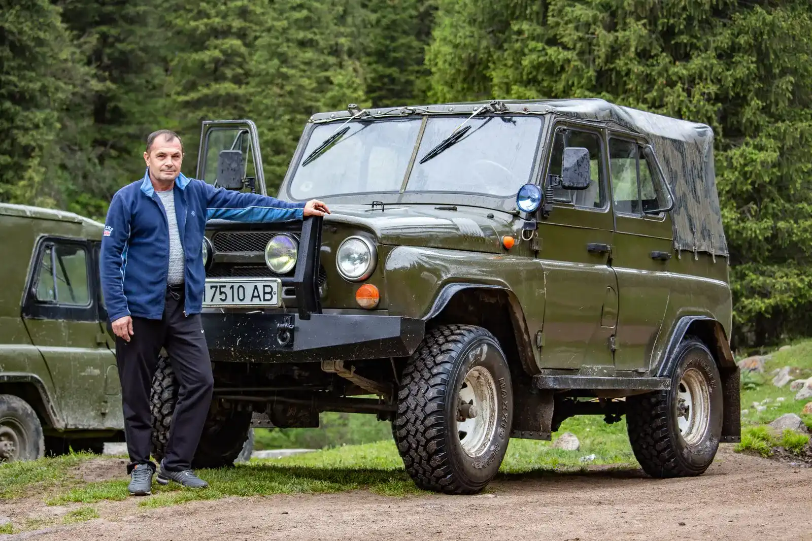 a man next to an UAZ in the mountains of Kyrgyzstan